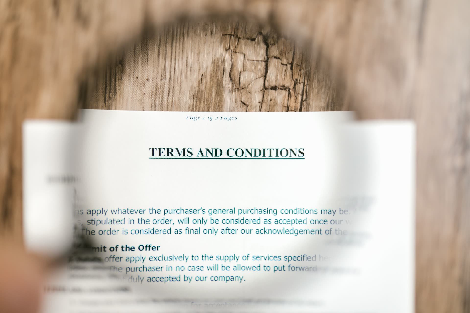 Documento de términos y condiciones con lupa sobre madera — la cláusula de cambio de control en un contrato ALPR